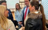 Uczestnicy międzynarodowego spotkania akademickiego rozmawiają w sali konferencyjnej; na ekranie w tle widoczne jest logo Universidad Nacional del Oeste.