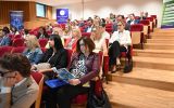 Publiczność zgromadzona w audytorium śledzi obrady konferencji.