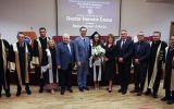 Grupowe zdjęcie uczestników ceremonii nadania tytułu Doctor Honoris Causa w sali akademickiej.