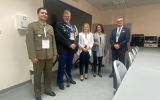 Pięć osób pozuje do zdjęcia w sali dydaktycznej Uniwersytetu Rzeszowskiego.