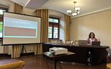 Prelegentka wygłasza referat dotyczący organizacji usług administracyjnych na rzecz osób starszych. Obok widoczny jest ekran z tytułem prezentacji.