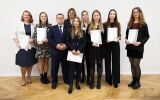 Rektor UR stoi  z nagrodzonymi studentkami, każda z nich trzyma w ręku dyplom