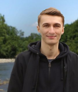 Doktor Łukasz Peszek - portret, w tle wielka rzeka  las