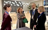 Czworo uczestników konferencji rozmawia przy stoliku w sali.
