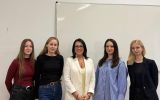 Pięć kobiet pozujących w sali dydaktycznej przed białą tablicą.