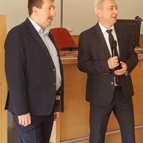 Zbliżenie na dwie osoby. Od lewej – Pełnomocnik Dyrektora Instytutu Ekonomii i Finansów Uniwersytetu Rzeszowskiego do spraw współpracy ze szkołami średnimi – dr Piotr Cyrek i Dyrektor Instytutu Ekonomii i Finansów Uniwersytetu Rzeszowskiego - dr hab. Rysz