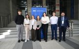 Grupa uczestników pozuje do zdjęcia przed budynkiem Uniwersytetu Rzeszowskiego przy banerze Wydziału Prawa i Administracji.