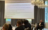 Prelegent omawia slajd „Czysta teoria prawa/normatywizm”; na pierwszym planie siedzą uczestnicy konferencji.