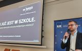 Prelegent mówi o sztucznej inteligencji w edukacji; obok wyświetlony jest tytuł wystąpienia.