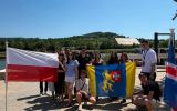 Studenci ELSA Rzeszów trzymają flagę Polski oraz flagę z herbem Rzeszowa podczas wizyty w Schengen.