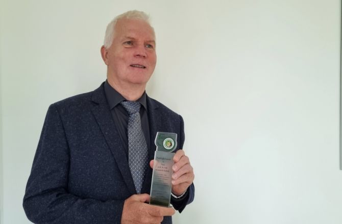 Prof Kukuła trzyma w ręku statuetkę z podziękowaniami