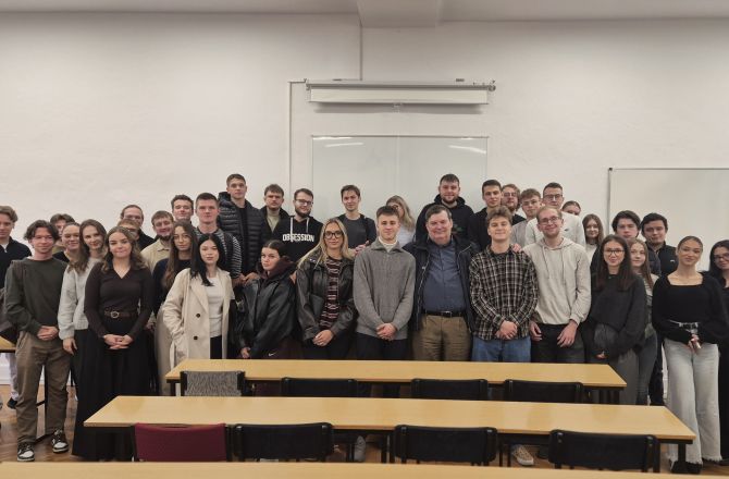 Zdjęcie grupowe studentów pozujących w sali wykładowej.