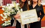Dwie uczestniczki uroczystości stoją trzymając dyplom Doctor Honoris Causa.