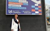 Uczestniczka wizyty akademickiej przed budynkiem Universidade Christus – Campus Dom Luís w Brazylii, na tle tablicy informującej o kierunkach studiów.
