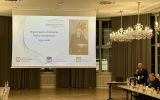Mówca wspomina prof. Marka Maciejewskiego; na ekranie widnieje jego fotografia i daty 1950–2026.