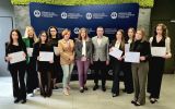 Grupa uczestniczek oraz przedstawiciele organizatorów pozują do wspólnego zdjęcia z dyplomami na tle ścianki Okręgowej Izby Radców Prawnych w Rzeszowie.
