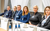 Uczestnicy spotkania siedzą przy stole obrad podczas rozmów w Ministerstwie Nauki i Szkolnictwa Wyższego.
