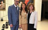 Troje uczestników uroczystości pozuje w holu uczelni pod portretem Ludwiga van Beethovena.
