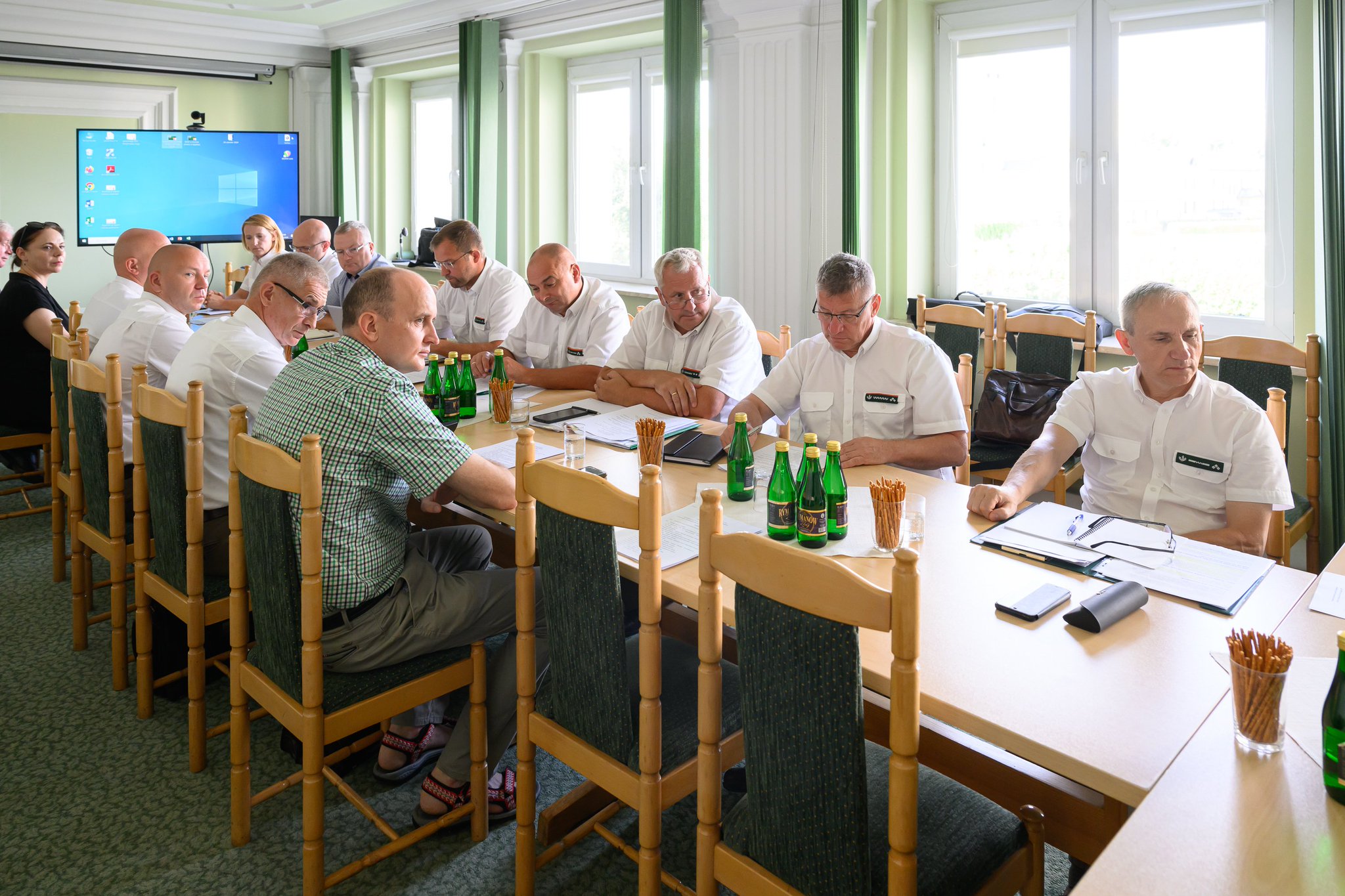 uczestnicy spotkania siedzą przy stole,