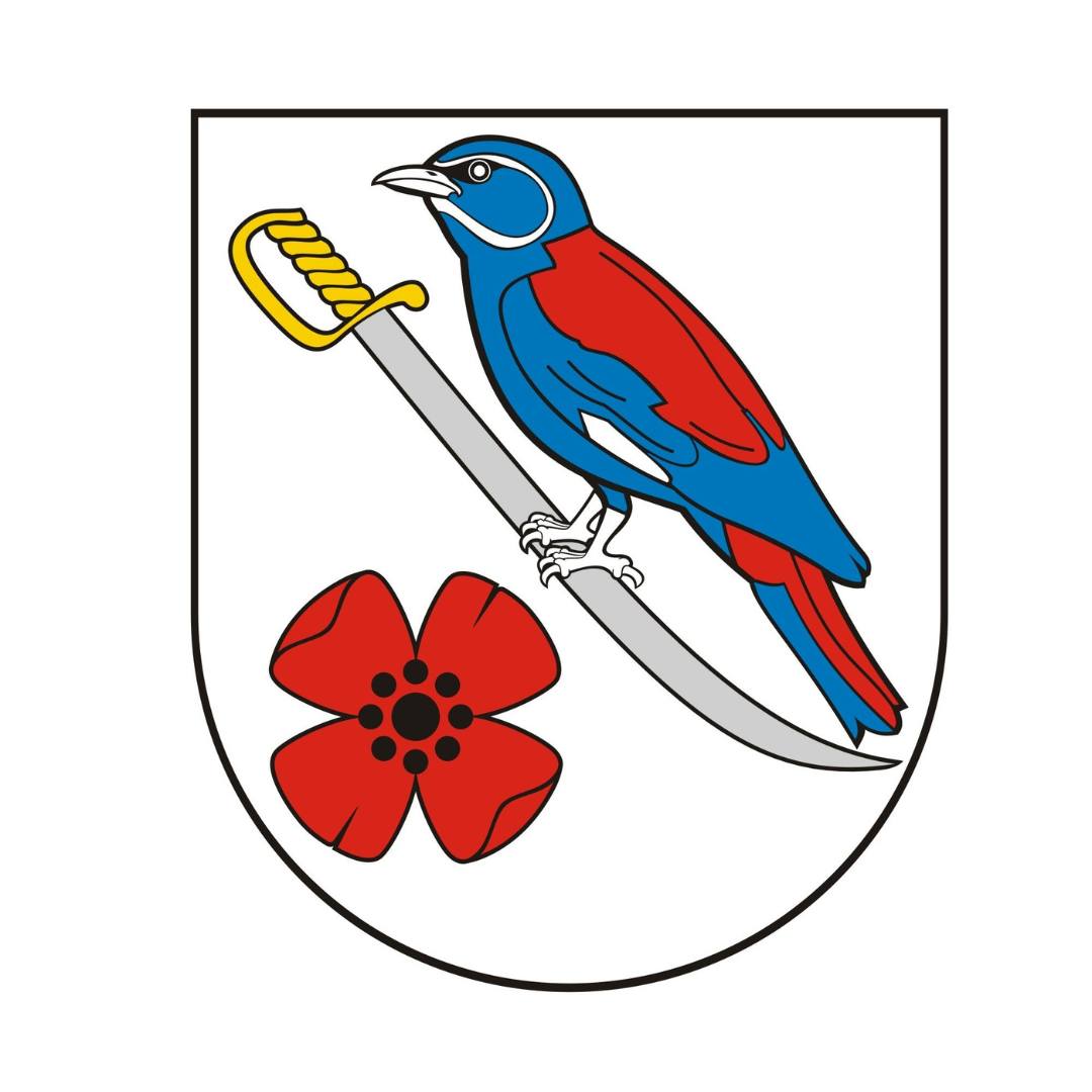 Herb gminy Krasne na tarczy w polu srebrnym niebiesko-czerwona kraska, siedząca na srebrnej szabli z prawa w skos ze złotą klingą, pod którą jest czerwony kwiat maku